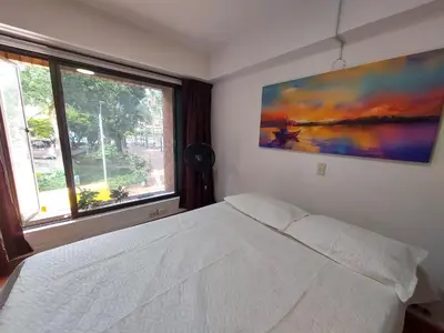 a bedroom with a white bed and a large window at Apartamentos Tipo Loft Parque del Poblado in Medellín