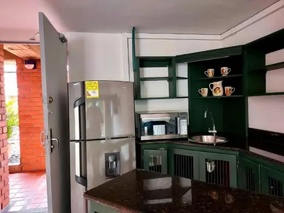 a kitchen with green cabinets and a stainless steel refrigerator at Apartamentos Tipo Loft Parque del Poblado in Medellín