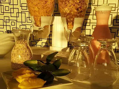 a table with three glass vases and a plate of food at Europa Hotel Boutique Manizales in Manizales