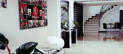 a living room with a staircase with a white chair at Europa Hotel Boutique Manizales in Manizales