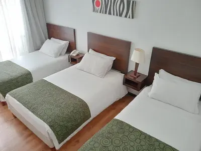 a hotel room with two beds and a telephone at Europa Hotel Boutique Manizales in Manizales