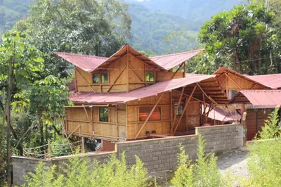 a wooden house in the middle of a forest at hermosa cabaña villa majo, cuenta con el espectacular rio santo domingo in San Francisco