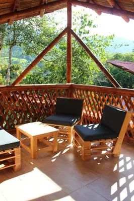 a screened in porch with two chairs and a table at hermosa cabaña villa majo, cuenta con el espectacular rio santo domingo in San Francisco