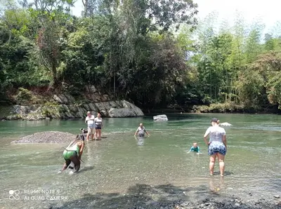 a group of people standing in the water in a river at hermosa cabaña villa majo, cuenta con el espectacular rio santo domingo in San Francisco