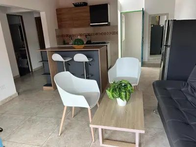 a living room with a table and white chairs at vista piedra in Guatapé