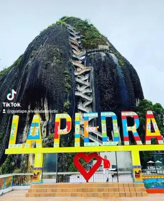 a sign in front of a mountain with the word alpina at vista piedra in Guatapé