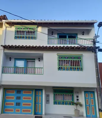 a white house with colorful doors and windows at vista piedra in Guatapé