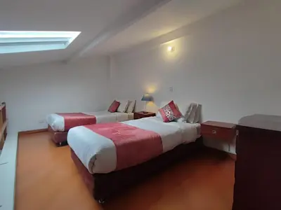 a hotel room with two beds and a window at Hotel Casa Galvez in Manizales