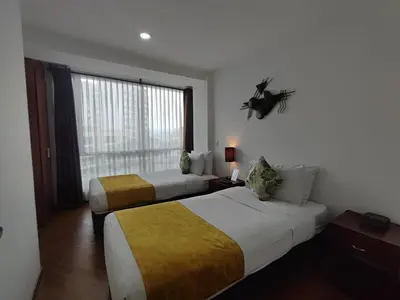 a hotel room with two beds and a window at Hotel Casa Galvez in Manizales