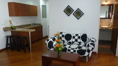a living room with a cow print couch and a table at Hotel Casa Galvez in Manizales