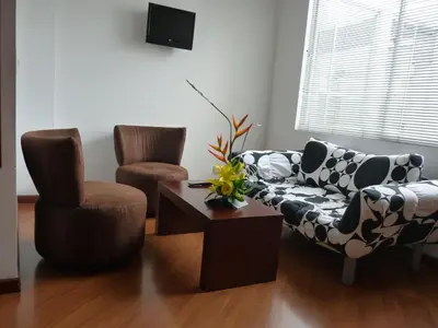 a living room with two chairs and a couch and a table at Hotel Casa Galvez in Manizales