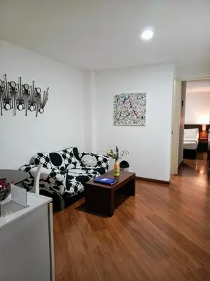 a living room with a black and white couch and a table at Hotel Casa Galvez in Manizales