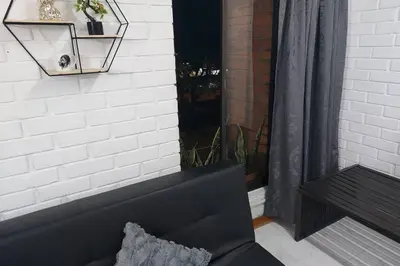 a black couch sitting in front of a window at Loft Poblado Park in Medellín