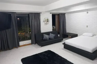 a bedroom with a bed and a couch at Loft Poblado Park in Medellín