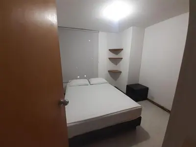 a small white room with a bed and a light at Furnished apartments for rent in Medellín