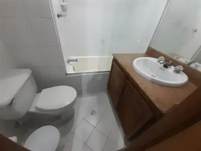 a white bathroom with a toilet and a sink at Furnished apartments for rent in Medellín