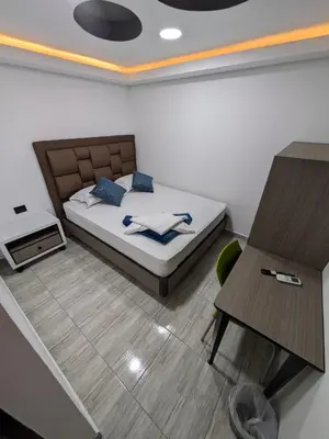 a bedroom with a bed and a table and a desk at Hostel Boutique Nido de Loros in Medellín