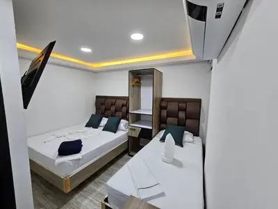a small bedroom with two beds and a mirror at Hostel Boutique Nido de Loros in Medellín