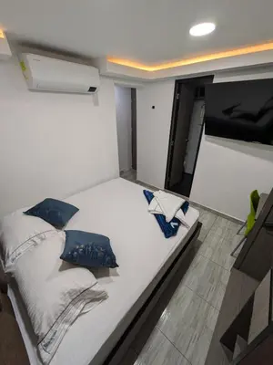 a bedroom with a large white bed with pillows on it at Hostel Boutique Nido de Loros in Medellín