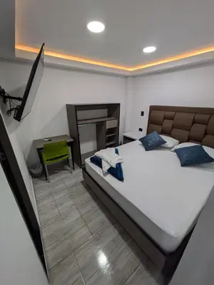 a bedroom with a large bed and a table at Hostel Boutique Nido de Loros in Medellín