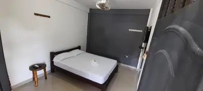 a small bedroom with a white bed and a table at La Orquidea in Mariquita