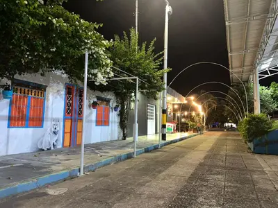 an empty street at night with a building with colorful doors at CASA DEL PARQUE Hotel, en Puerto Perales, corregimiento de Puerto triunfo 30 min del parque Nápoles in Puerto Perales