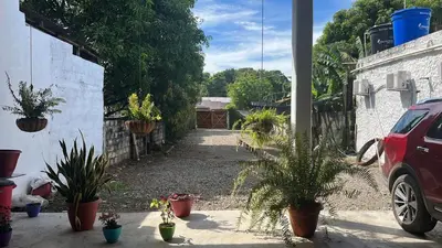 a driveway with potted plants in a yard at CASA DEL PARQUE Hotel, en Puerto Perales, corregimiento de Puerto triunfo 30 min del parque Nápoles in Puerto Perales
