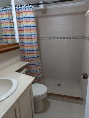 a bathroom with a shower curtain and a toilet at Apartamento en Parque del Poblado in Medellín