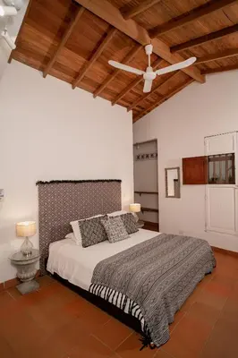 a bedroom with a large bed with a ceiling fan at Casa Al Alma in Santa Fe de Antioquia