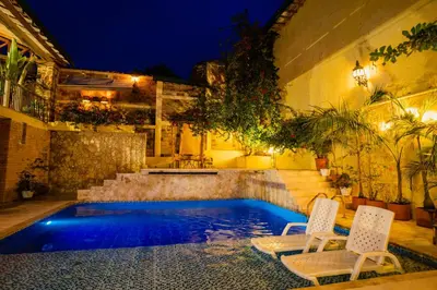 a swimming pool with two chairs next to a building at Casa Al Alma in Santa Fe de Antioquia