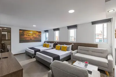 a living room with two beds and a couch at Hotel Velero in San Antonio de Pereira