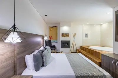 a bedroom with a large bed and a tub at Hotel Velero in San Antonio de Pereira
