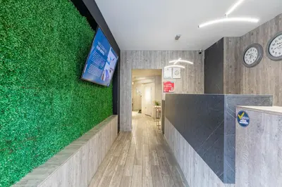 a green wall in an office with clocks on the wall at Hotel Velero in San Antonio de Pereira