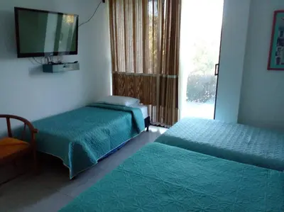 a bedroom with two beds and a tv and a window at Casa De Campo in Santuario