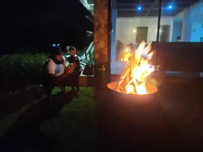 two people sitting around a fire pit at night at Casa De Campo in Santuario