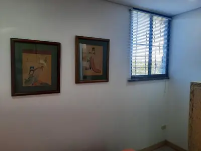 three framed pictures on a white wall with a window at Casa De Campo in Santuario