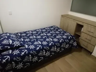 a bedroom with a blue and white bed and a dresser at Apartamento La Ceja in La Ceja