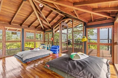 two beds in a room with wooden ceilings and windows at Gulupa Ecolodge in Jardin