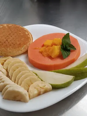 a plate of food with cheese crackers and fruit and a sandwich at Gulupa Ecolodge in Jardin
