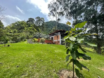a house on a hill with a green field at Gulupa Ecolodge in Jardin