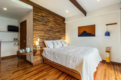 a bedroom with a bed and a brick wall at Gulupa Ecolodge in Jardin