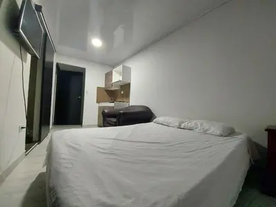 a bedroom with a white bed and a chair at Apartaestudio6 sector Cable Estadio in Manizales