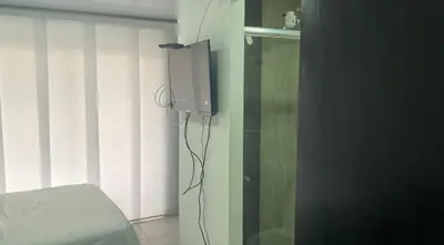 a bedroom with a tv on the wall next to a bed at Apartaestudio6 sector Cable Estadio in Manizales