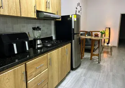a kitchen with a stainless steel refrigerator and a table at Apartamento Guatapé Plaza in Guatapé