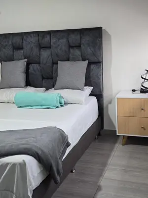 a bedroom with a large bed with a padded headboard at Apartamento Guatapé Plaza in Guatapé