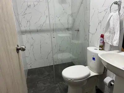 a bathroom with a toilet and a sink and a shower at Apartamento Guatapé Plaza in Guatapé
