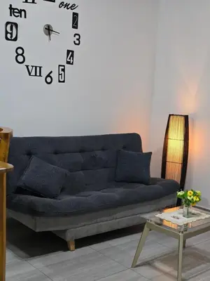 a blue couch in a living room with a clock on the wall at Apartamento Guatapé Plaza in Guatapé