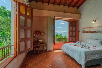 a bedroom with a bed and a balcony at Granja del Cafe Hotel y Centro de convenciones in Venecia