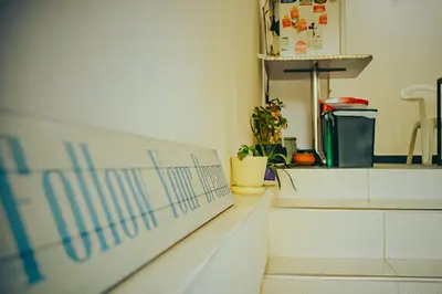 a staircase in a room with a kitchen with a counter at Hostel Metro Floresta Alojamiento in Medellín