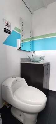 a bathroom with a white toilet and a sink at Hostel Metro Floresta Alojamiento in Medellín